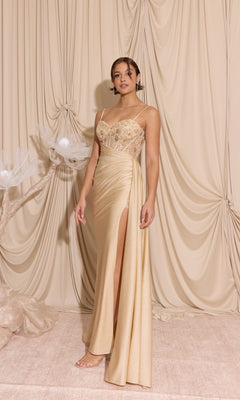 A woman poses before draped beige fabric, wearing the Eureka EK166 Long Prom Dress in Champagne, featuring a sheer-embroidered bodice, thin straps, delicate beading, and a high slit.