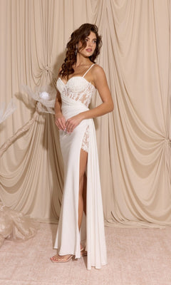 A woman in the Long Prom Dress: Eureka EK166, featuring lace details, a thigh-high slit, and a sheer-embroidered bodice, stands before beige draped curtains.