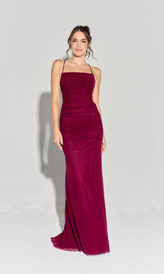 A woman models the Eureka EK177 Strappy-Back Slinky Long Prom Dress, a sleeveless, floor-length fitted burgundy gown with thin straps, against a plain light background.
