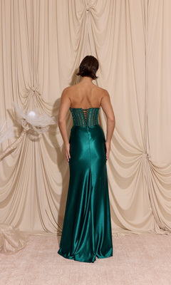 A woman faces away from the camera, wearing the Strapless Tight Satin Prom Dress: Eureka EK183 with a structured bodice, set against a cream draped fabric backdrop.