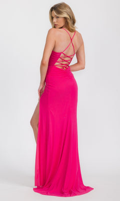 A woman stands against a white background, wearing the Eureka EK187B Lace-Up Long Neon Formal Dress featuring a bright pink hue, strappy open back, and a side slit, while looking over her shoulder.