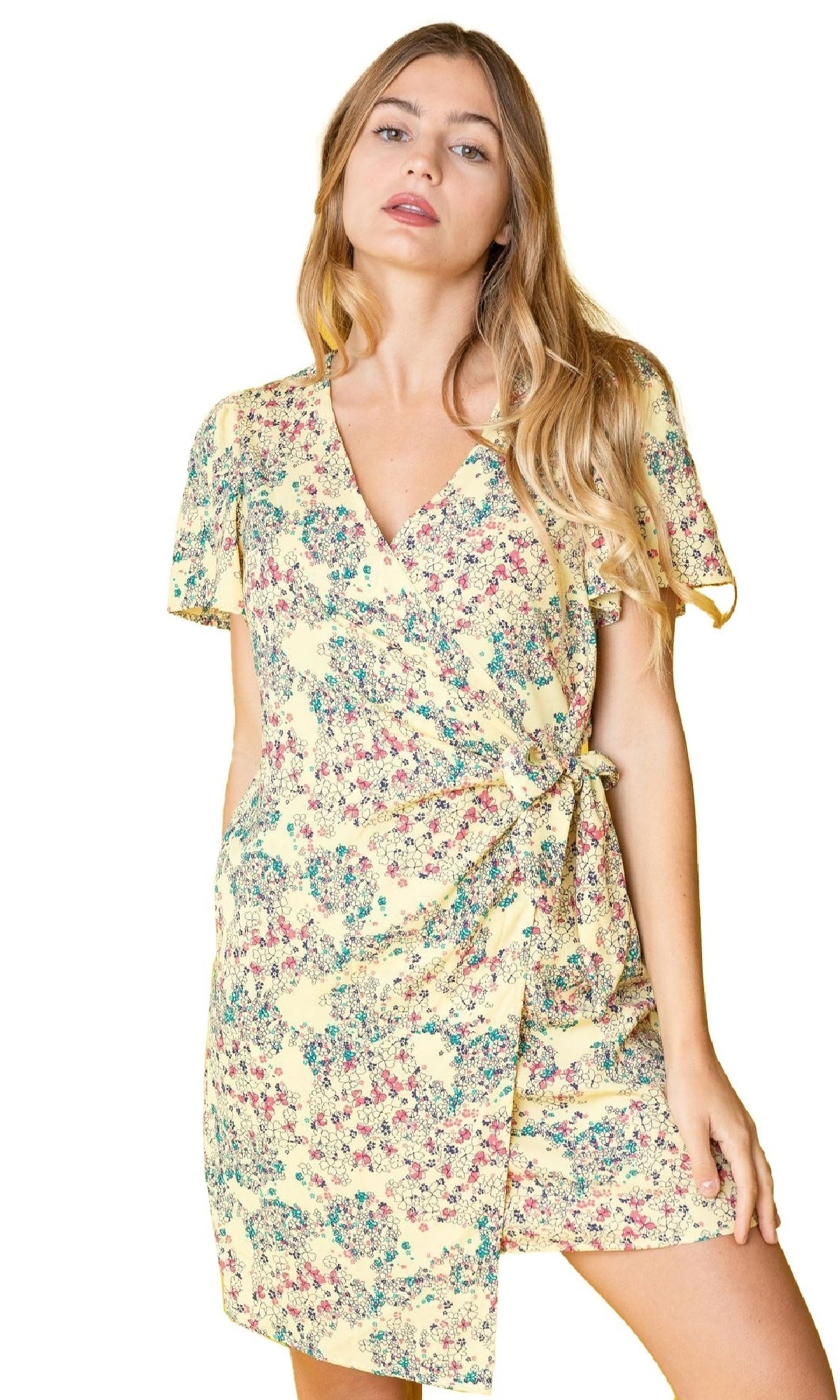 A woman wears the Floral Print Casual Short Wrap Dress, featuring short sleeves, a yellow floral design, v-neckline, and side tie—ideal for a casual look against a white background.
