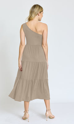A woman, seen from behind, wears the One-Shoulder Casual Everyday Midi Dress in taupe with tiered layers and nude heels, standing against a plain white background.