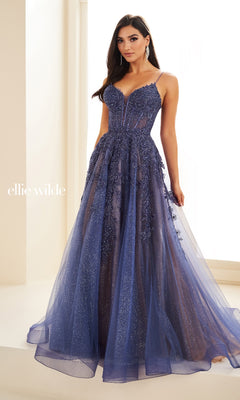 A woman stands indoors by a window wearing the Sheer-Corset Long Lace Prom Ball Gown EW34036, featuring thin straps, a fitted bodice, and an embellished tulle skirt.