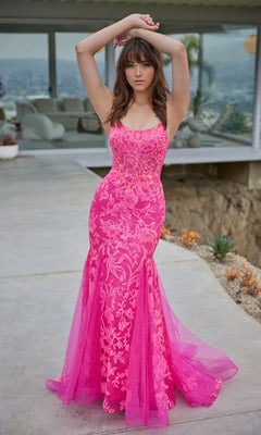A woman stands outdoors wearing the Ellie Wilde Sequin Long Mermaid Prom Dress EW35008, featuring bright pink sequins and elegant sheer detailing.