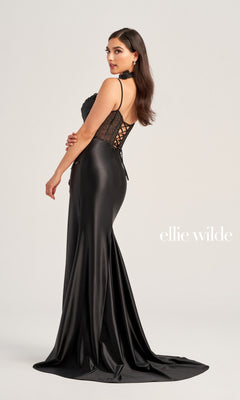A woman models the Ellie Wilde Choker Designer Prom Dress EW35028, a floor-length black satin gown with a lace-up corset back and elegant beaded-lace floral appliques on one side.