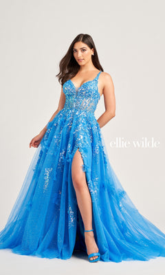 A woman wearing the Long Glitter Prom Ball Gown EW35047 by Ellie Wilde, featuring vibrant blue sequins, floral embellishments, and a high slit, poses against a plain background with "Ellie Wilde" text beside her.