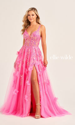 A woman models the Long Glitter Prom Ball Gown EW35047 by Ellie Wilde, featuring a bright pink shade, high slit, and floral appliqué embellishments, standing against a plain light background. The text "ellie wilde" appears beside her.