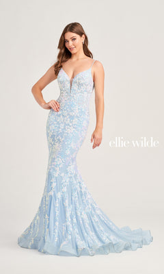 A woman models the Ellie Wilde Long Mermaid Designer Dress EW35048, featuring light blue floral lace, sequins, a plunging neckline, and a figure-hugging silhouette. "Ellie Wilde" is displayed beside her against a plain background.