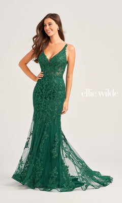 A woman wears the Ellie Wilde Long Glitter-Lace Prom Dress EW35071—an emerald green, fitted, floor-length gown with floral embroidery and thin straps. The "ellie wilde" logo is displayed on the right against a plain background.