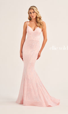 A woman poses against a plain light background wearing the Ellie Wilde Long Mermaid Formal Dress EW35083—a fitted, light pink, floor-length mermaid gown with thin straps and subtle floral embellishments.