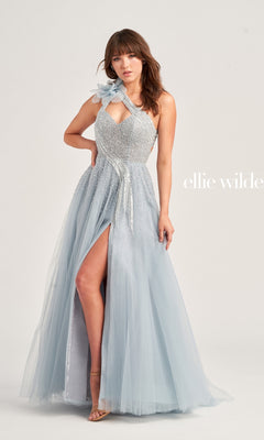 A woman wears the Long Prom Dress EW35086 by Ellie Wilde, a light blue, one-shoulder ball gown with a high slit and beaded details, standing against a plain background.