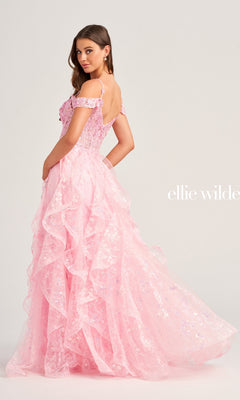 A woman poses with her back slightly turned, wearing the pink Ellie Wilde Ruffled Long Prom Ball Gown EW35218 against a plain background.