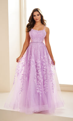 A woman stands indoors near a window, holding the sides of her skirt while wearing the Ellie Wilde EW36068 long prom dress featuring sleeveless design with lace and floral embroidery in lavender.