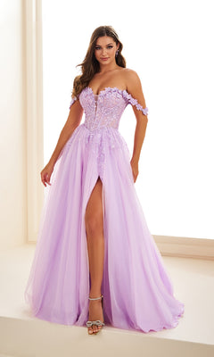 A woman stands in a bright room wearing the Ellie Wilde EW36214 long prom dress, featuring lavender tulle, an off-the-shoulder neckline, floral lace applique corset bodice, a-line silhouette, and a high slit.