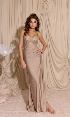 A woman wears the Eureka EK166 Long Prom Dress, featuring a sheer-embroidered bodice and fitted champagne-colored floor-length gown, posing before draped beige fabric.