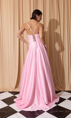 A woman in the Eureka EK190 long prom dress—light pink satin with crisscross straps and an open back—stands on a black and white tiled floor facing a beige curtain.