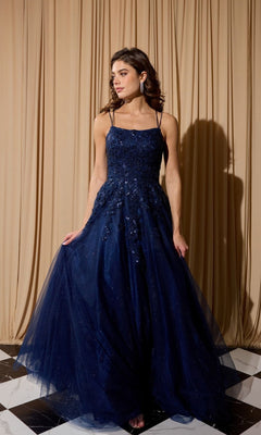 A woman in the Eureka EK197 long prom dress in navy stands on a black and white checkered floor before beige curtains.