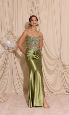 A woman stands before beige drapes wearing the Eureka EK202 long prom dress—a strapless, fitted sage gown with a satin sheath skirt, sequined accents, and a side slit.