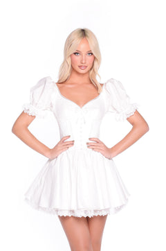 A woman models the White Short Graduation Dress: Emely, featuring puff sleeves, lace trim, and a corset-style bodice, standing against a plain white background.