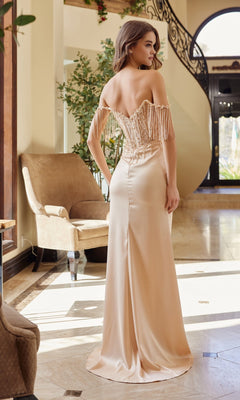 A woman in the Nox Anabel F1571 Beaded-Bodice Long Prom Dress stands indoors, facing away, in a bright, elegant room featuring a staircase and armchair.