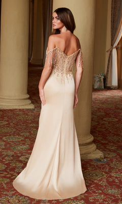 A woman stands with her back to the camera in the Nox Anabel F1571 Beaded-Bodice Long Prom Dress, showcasing off-the-shoulder style, a beaded bodice, and fringe details in an ornate room with columns and patterned carpet.