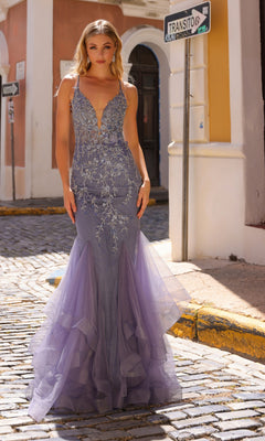A woman stands on a cobblestone street wearing the Lace-Up-Back Long Mermaid Prom Dress G1368, featuring a fitted silhouette, silver embellishments, and a tulle mermaid skirt.