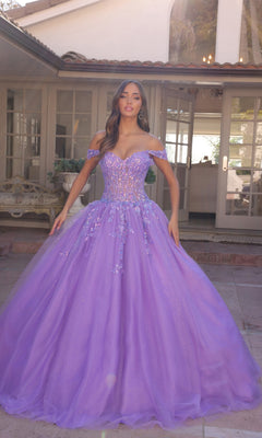 A woman stands outside a house wearing the Bright Off-the-Shoulder Long Prom Ball Gown H1349 in lavender, featuring a sparkling off-the-shoulder design, full tulle skirt, and delicate floral embellishments.
