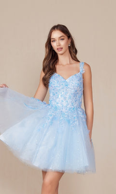 A woman in the Embroidered-Bodice Short A-Line Hoco Dress H846, featuring a light blue hue, floral embellished bodice, and tulle skirt, stands against a plain beige background.