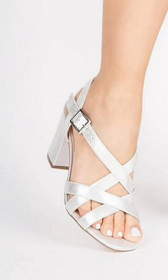 Hilde Silver Prom Shoes: Paradox London P2405 in silver, featuring a block heel, buckled ankle strap, and crisscross front straps worn on a foot.
