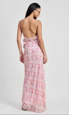 A woman with long dark hair models the Pink Floral Backless Summer Maxi Dress, featuring thin straps and an open back, against a plain light background.