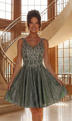 A woman wears the green Beaded-Bodice Short Glitter Homecoming Dress J009, featuring a sleeveless design with silver embellishments, as she stands smiling indoors before a curved staircase and large windows.