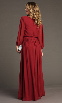 A woman stands with her back to the camera, wearing the Long-Sleeve Long Formal Dress: Chicas J012B in red and holding a silver clutch.