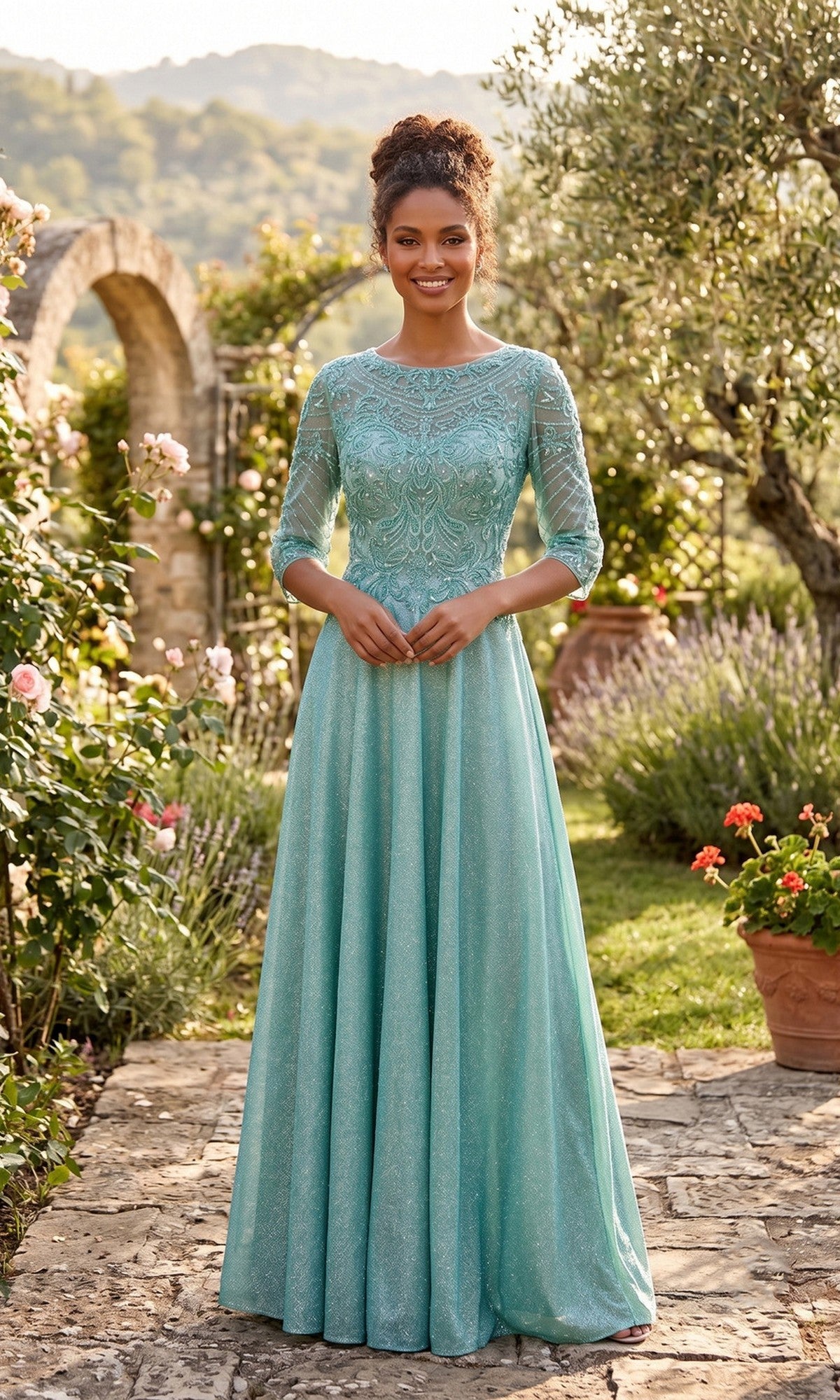 A woman stands outdoors on a stone path wearing the Chicas J052 Long Formal Dress—a modest sage-colored gown featuring lace detailing and three-quarter sleeves. The blooming garden and archway in the background enhance the graceful charm of her elegant look.