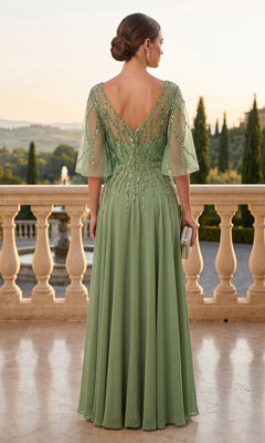 Wearing the Long Prom Dress: Chicas J064—a light green, floor-length chiffon A-line gown with beaded details and sheer sleeves—a woman stands on a balcony, facing away, holding a small clutch.