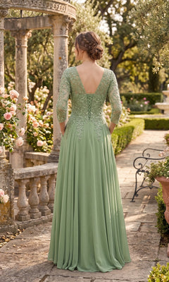 A woman wearing the Long Prom Dress: Chicas J070 in light green stands outdoors on a stone path, surrounded by flowers and greenery, facing away from the camera—a graceful look reminiscent of an elegant mother of the bride dress.