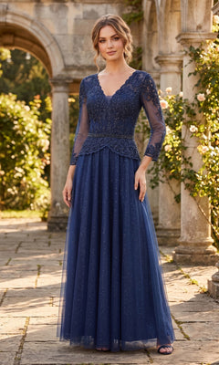 A woman wearing the Chicas J082 Long Prom Dress in navy, featuring elegant three-quarter sleeves, lace detailing, and an embellished bodice, stands outdoors on a stone path near an archway and lush greenery—the perfect graceful look for a mother of the bride in a formal gown.