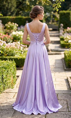 Wearing the Long Prom Dress: Chicas J112, a woman stands on a stone path in a garden with her hair in an updo, facing away.