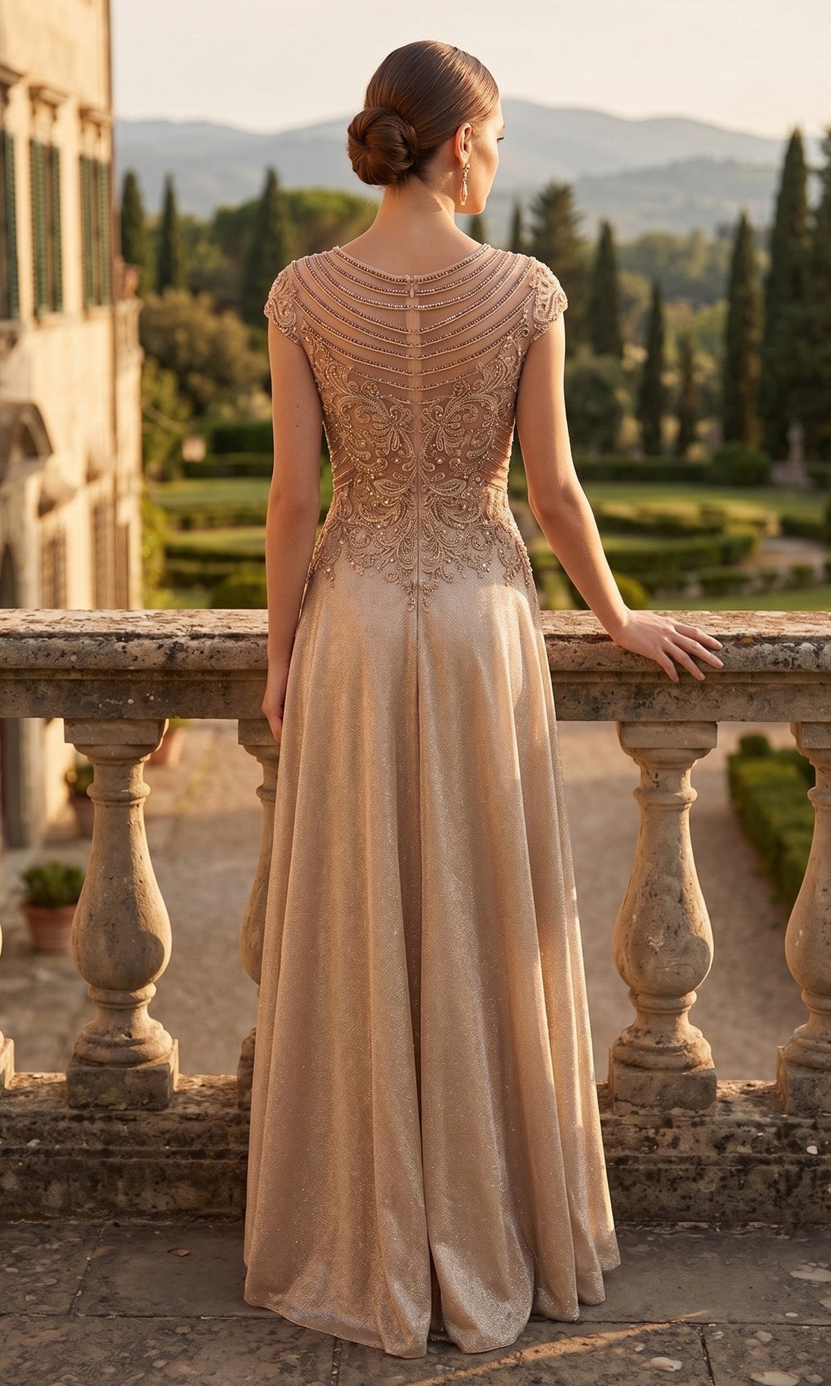Wearing the Long Prom Dress: Chicas J132, a woman stands on a stone balcony in a formal gown featuring an embellished bodice and sparkling A-line skirt, gazing out at a landscaped garden and distant hills.