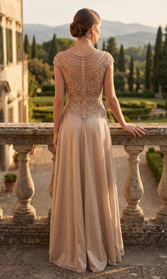 Wearing the Long Prom Dress: Chicas J132, a woman stands on a stone balcony in a formal gown featuring an embellished bodice and sparkling A-line skirt, gazing out at a landscaped garden and distant hills.
