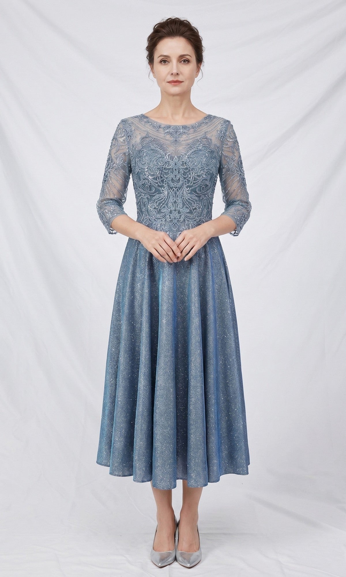 A woman wearing the Modest Midi Wedding Guest Dress: Chicas J152 in blue—a knee-length, lace A-line midi dress with three-quarter sleeves—stands against a plain white background, showcasing an elegant choice for wedding guests.
