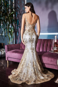 Woman modeling the back of a long gold dress she's wearing standing in front of a velvet purple couch.