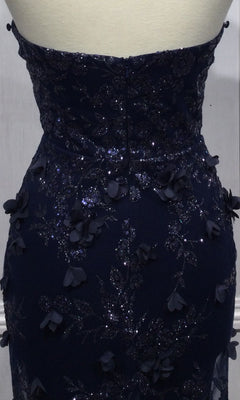 Close-up of the back of the Strapless Long Pageant Dress with Cape J834 in dark blue, shown on a mannequin. Features a sweetheart neckline, floral appliqué, and glittery details.