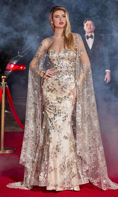 A woman in the Strapless Long Pageant Dress with Cape J834 stands on a red carpet, featuring a glitter print, sweetheart neckline, and sheer cape; a man in a tuxedo and a car are visible in the smoky background.