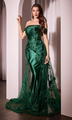 Woman in a floor-length, emerald green Ladivine J876 prom dress with tulle overskirt and floral appliqués, posing gracefully before a white archway.