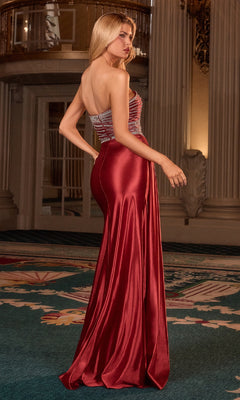 Woman in a red evening gown standing in an elegant interior setting.