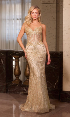 A woman stands indoors against a marble railing and textured wall, wearing the gold Sheer-Sides Strapless Prom Gown (Ladivine J888) with a fitted silhouette and intricate beading.