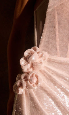 Close-up of the Ladivine J905 long prom dress in light pink sequined fabric, showcasing three elegant fabric flower embellishments at the waist.