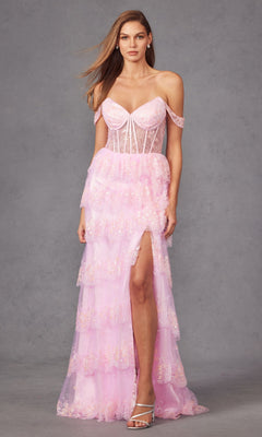 A woman poses against a gray background in the Long Prom Dress JT2453K by Juliet, featuring a light pink off-the-shoulder design with a sheer corset bodice, tiered ruffle tulle skirt, thigh-high slit, and floral embellishments.