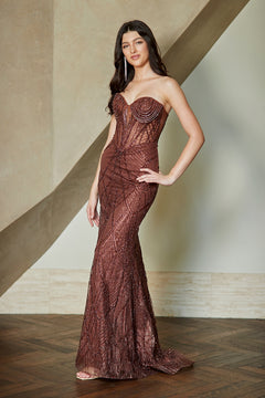 A person wearing a brown Amelia Couture JQ1107 strapless, floor-length gown with a corset-style bodice and vertical beaded embellishments.